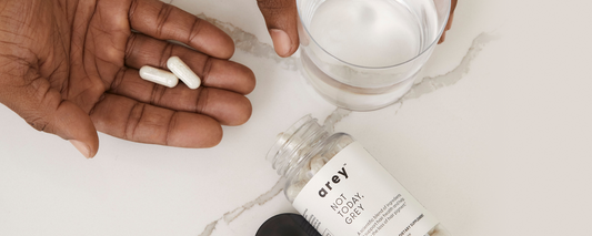 Image of a man’s hand holding a dose of Arey not Today, Grey - a grey hair solution containing the best vitamins to preserve hair color.