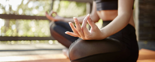 woman meditating to reduce grey hair caused by stress