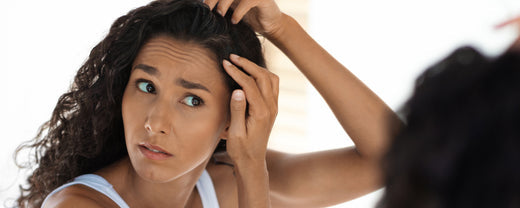 Woman looks in mirror and sees her hair turning grey