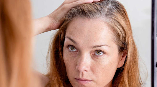 Woman checks her scalp health in the mirror