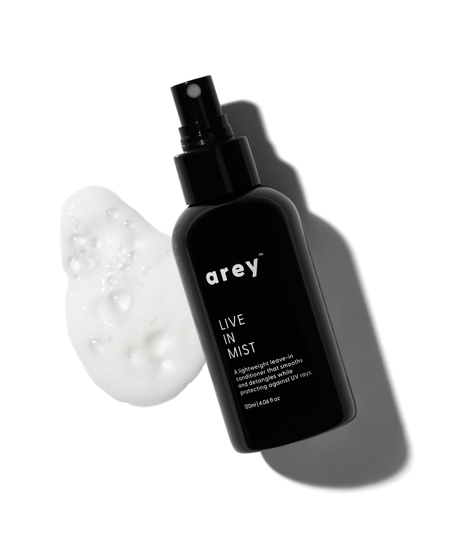 black spray bottle with white pool of product